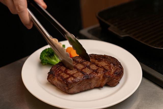 chef-plates-juicy-ribeye-steak-with-tongs